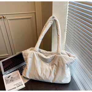 Close-up of white quilted nylon tote bag in an office setting with natural sunlight
