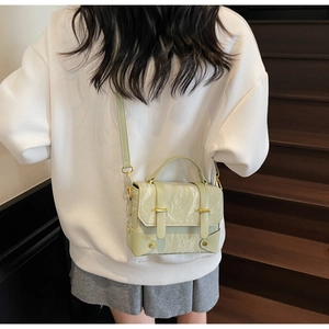 Détail du sac messager carré vert menthe texturé avec ferrures dorées et doubles boucles