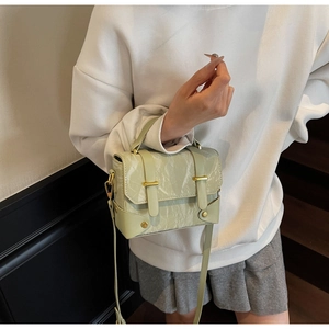 Détail d'un sac à main vert menthe à motif marbré avec des ferrures dorées