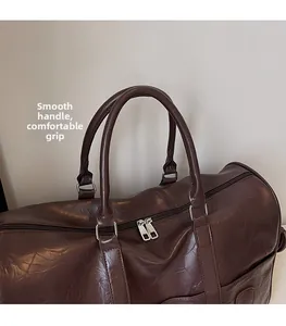 Détail du sac de voyage en similicuir avec poignées arrondies confortables et fermetures