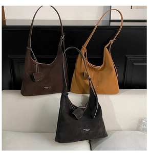 Detailed close-up showing the suede texture and minimalist metal buckles of hobo bags