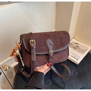 Detail of vintage matte brown shoulder bag with decorative beads and metal buckle