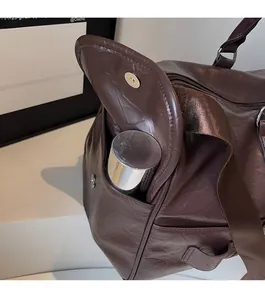 Détail de la poche latérale du sac de voyage avec fermoir magnétique et gourde incluse