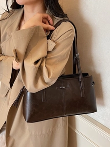 Retro dark brown leather underarm bag with rectangular silhouette and metal logo
