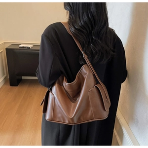 Detail view of the large capacity dark brown soft leather underarm bag with side pockets
