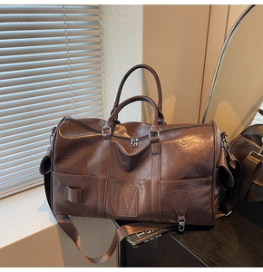 Détail du sac de voyage marron avec texture plissée vintage et bandoulière amovible