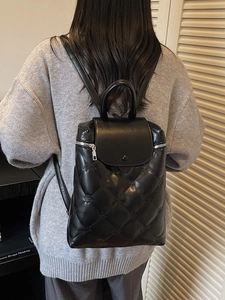 Chic black quilted backpack with monogram pattern and top handle for women
