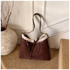 Detailed view of brown suede shoulder bag with cream faux fur trim and bow decoration
