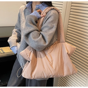 Quilted puffer tote bag in dusty rose worn by a model for a casual daily look