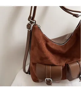 Detail of adjustable shoulder strap and smooth brown suede texture on vintage tote bag