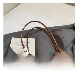 Detail of vintage brown tweed tote bag with leather handles and decorative canvas strap
