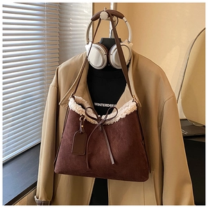 Detail of dark brown suede shoulder bag with white faux fur trim and delicate bow tie