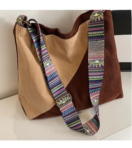 Detail of corduroy tote bag featuring adjustable wide strap with colorful geometric pattern