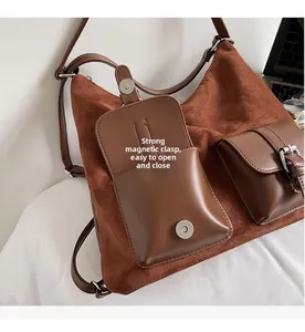 Detail of brown faux suede tote bag featuring strong magnetic buckles and strap hardware