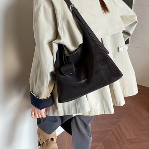 Detail of dark brown hobo shoulder bag with adjustable strap and front pocket detail
