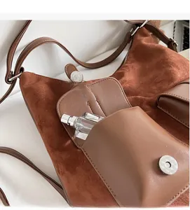 Detail view of large brown suede tote bag showing front flap pocket and spacious interior