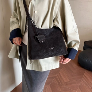 Detail of retro textured dark brown Hobo bag with knot charm and fashion branding