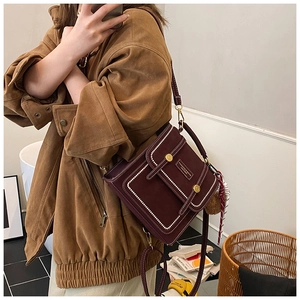 Detail of burgundy retro backpack with contrast stitching and patterned silk scarf