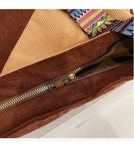 Detailed close-up of corduroy tote bag with metal zipper and bohemian patterned strap