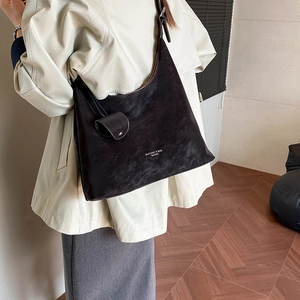Detail of retro oversized hobo bag with matte finish and mini strap pouch accessory