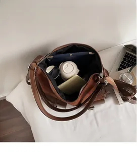 Top view showing the large internal capacity of the brown tote bag with various items