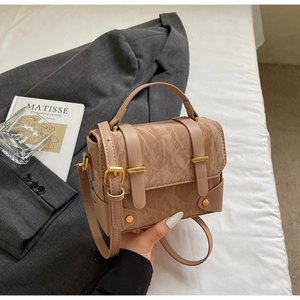 Gros plan du sac bandoulière nude élégant avec rabat marbré et boucles dorées