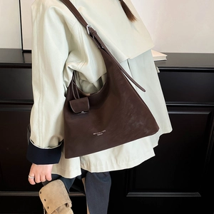 Close-up of minimalist dark brown underarm tote bag with adjustable shoulder strap