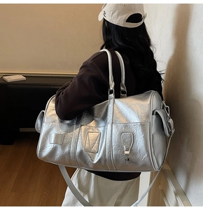 Gros plan d'un sac de voyage argenté avec texture métallisée et grande poche latérale