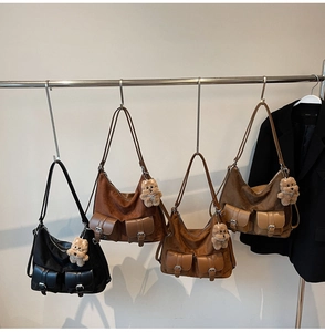 Detailed display of large suede tote bags with utility pockets and bear charms