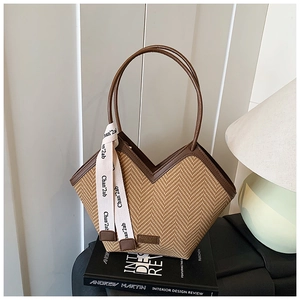 Detailed view of woven tote bag with V-shaped opening and brown leather trim details