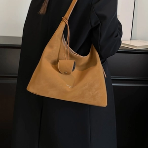 Detail of camel leather shoulder bag with logo and matching mini pouch accessory