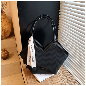 Detail of large black tote bag with V-shaped design and woven texture with handle