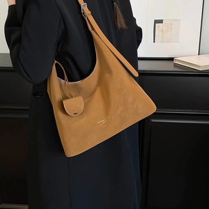 Detailed view of camel hobo bag with adjustable strap and round coin purse accessory