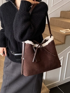 Brown faux suede shoulder bag with plush white fur trim and drawstring bow detail