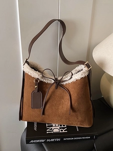 Brown suede underarm bucket bag with white faux fur trim and adjustable strap for women