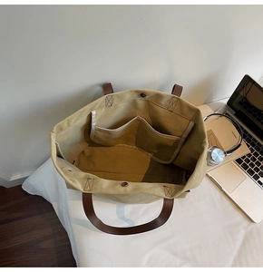 Interior view of khaki canvas tote showing magnetic closure and inner pockets