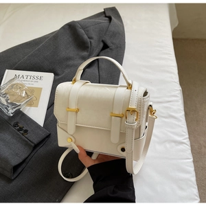 Détail du sac bandoulière blanc en cuir PU avec texture litchi et boucle dorée chic