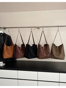 Hanging display of large hobo bucket bags in suede finishes and various colors