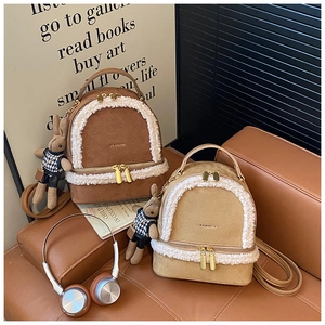 Close-up of mini backpacks with faux shearling trim and cute bunny charm accessory
