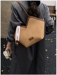 Detailed view of herringbone tote bag on a model in an autumn outdoor street setting