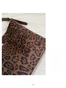 Close-up of leopard print shoulder bag featuring premium brown leather strap and silver buckle