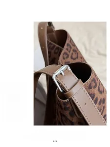 Macro detail of leopard print bucket bag with silver buckle and brown leather strap