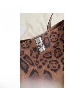 Macro detail of brown leopard print bucket bag featuring a silver metal twist lock closure