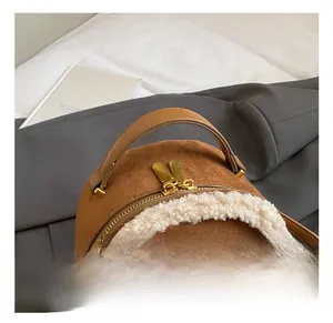 Detailansicht des braunen Wildlederrucksacks mit Lammfellbesatz und goldenem Griff