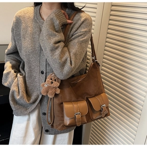 Brown suede tote bag with leather pockets and a cute teddy bear charm on shoulder