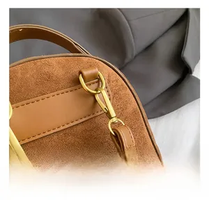 Nahaufnahme der goldenen Metallhaken und Wildleder-Textur am Winter-Plüschrucksack