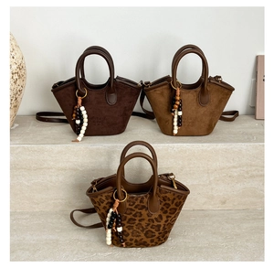 Detailed shot of leather mini tote bags with beaded charms in brown and leopard print