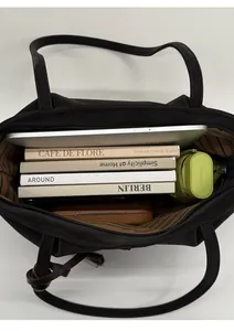 Top view of spacious black tote bag interior showing laptop and books for daily use