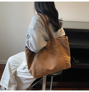 Side view of a large brown canvas tote bag worn by a model in a retro aesthetic setting