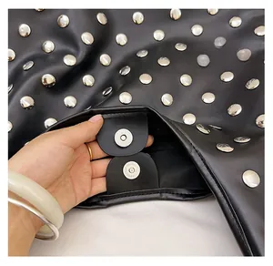 Detail of silver magnetic buckle on black vintage rivet shoulder bag with metal studs